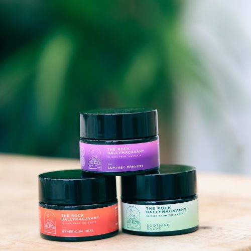 3 containers of salves, stacked in a pyramid, with hypericum heal on the bottom left, soothing salve on the bottom right, and comfrey comfort sitting on top of both